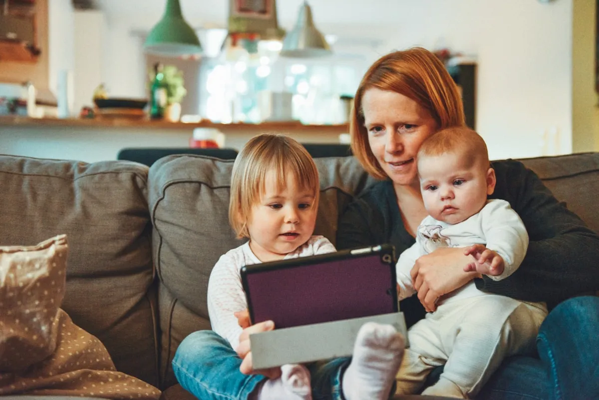 Mutter mit zwei Kindern am Tablet